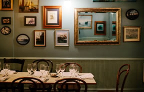 Table by photo frames on wall.