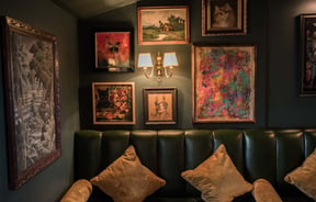 Artwork on wall by green leather booth.
