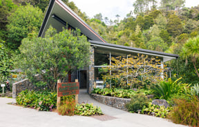 Exterior of Quail Cafe surrounded by lush gardens.