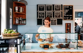 A young woman serving a pie inside Relish cafe in Rangitikei.
