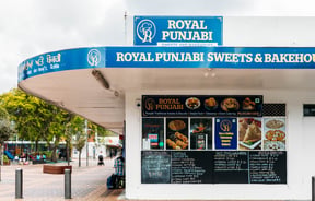 Exterior view of the corner shop Royal Punjabi Sweets and Bake House.