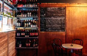 Wood panelling on the walls inside a dimly lite bar.