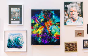 Bright colourful artworks hanging on the wall.