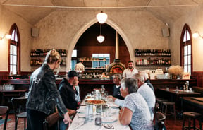 Customers dining at a large table at Sundays in Queenstown.