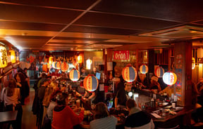 A packed restaurant on a dark night.
