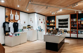 Gift shop with products on shelves and display tables at Waikato Museum.
