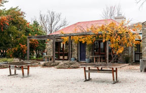 Schist building exterior and outdoor tables at Terra Sancta.