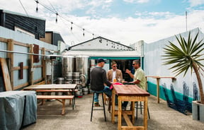 The outside courtyard at The Beer Engine where three guys are sitting around a table drinking beer.