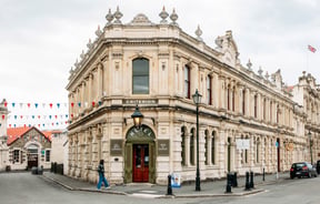 Exterior of The Criterion Hotel in Ōamaru with a person walking past the front in a checkered jacket