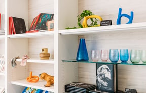 Cups and vases on display in a gallery gift shop.