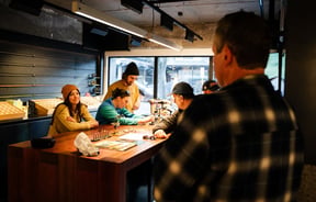 A group of people making flys at Patagonia's Fly Bar in Queenstown.