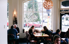 Customers dining in at tables by the window.