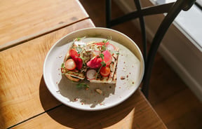 A close up of loaded toast on a table in the sunshine at the Greedy Cow in Tekapo.