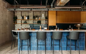 High seats placed around a kitchen and bar area.