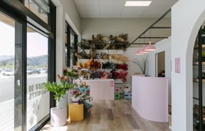 The interior of The Green Room flower and plant store with light pink counters.
