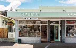 Mint green building exterior of The Wobbly Pot.