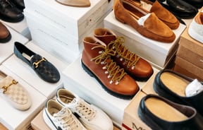 A close up of shoes and boots on display inside a retail store.