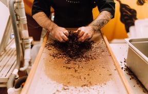 A man making chocolate with his hands.
