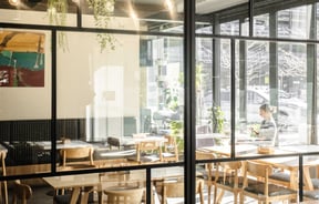 Pale wood wall and cafe seating with industrial lights at Westend Stories..