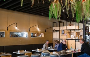 Customers dining inside a brightly lit cafe.