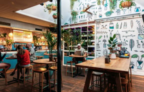 Customers dining inside a brightly decorated Queenstown cafe.