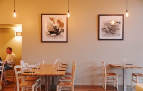 Table set at Zephyr with artwork hanging above.