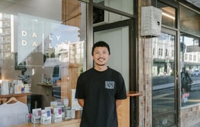 Albert outside his cafe smiling to camera.