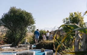 Kids playing mini golf with their parents on a sunny day.