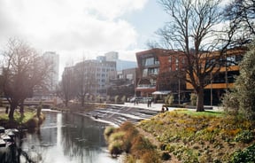 Buildings lined up alongside a river on a sunny day.