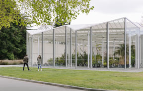 Two people spending time outside a glasshouse at Christchurch Botanic Gardens.