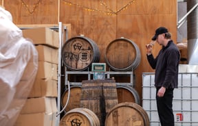A distiller tasting and sampling a spirit in the workshop at The Spirits Workshop.