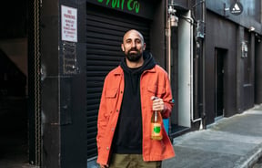 Cosmo holding a bottle of Fruit Cru.