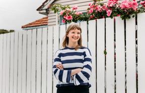 A woman wearing a stripped top smiling.