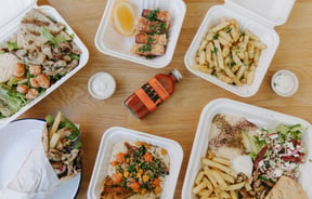 A flatlay of salads and hot chips on a table at Zeek's.