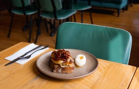 Elevated version of french toast with grilled bananas and a quenelle of cream on the side