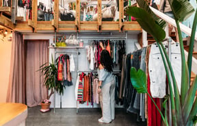 Customer browsing clothing racks in a vintage store.