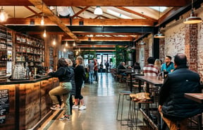 Customers at the bar at Brew Union.