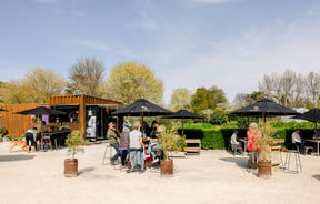 Outdoor seating with customers at Red Bridge Coffee.