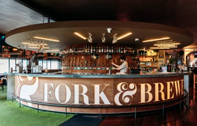 Bartender behind the bar at Fork & Brewer.