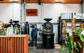 Man standing at coffee bean roaster.