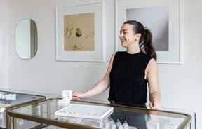 Shop assistant behind a jewellery counter.