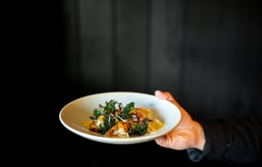 A hand holding a plate of food.