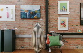 Interior view of art hanging on a brick wall at 77 Art + Living.