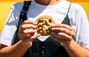 A woman holding a cookie in two hands.