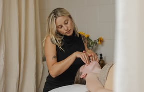 Beauty therapist at Face.it Sumner giving facial treatment to client