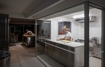 Two bakers working in the empty bakery in the dark morning.