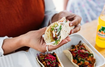 Close up of a person's hands holding a taco.