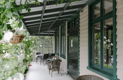 A covered verandah outside Cafe Verde, surrounded by greenery in Geraldine.