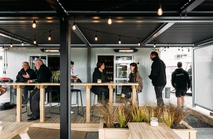 Customers chatting at tables outside the cafe.