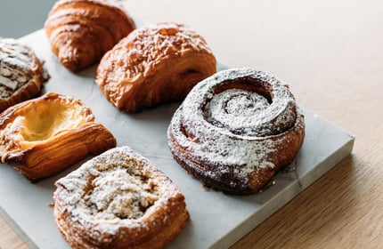 Pastries on a board on top of a wooden counter.